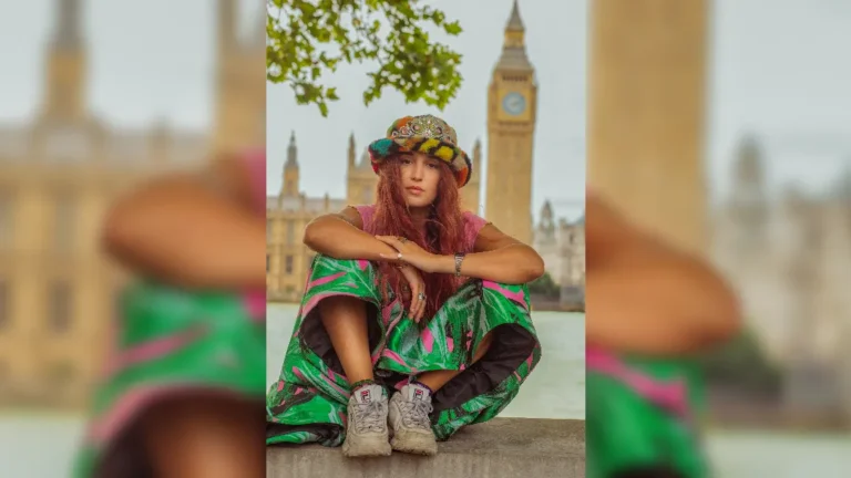 promotional image of Rubberband Girl sat in through of the Thames and Parliament - image courtesy Melody Berkery