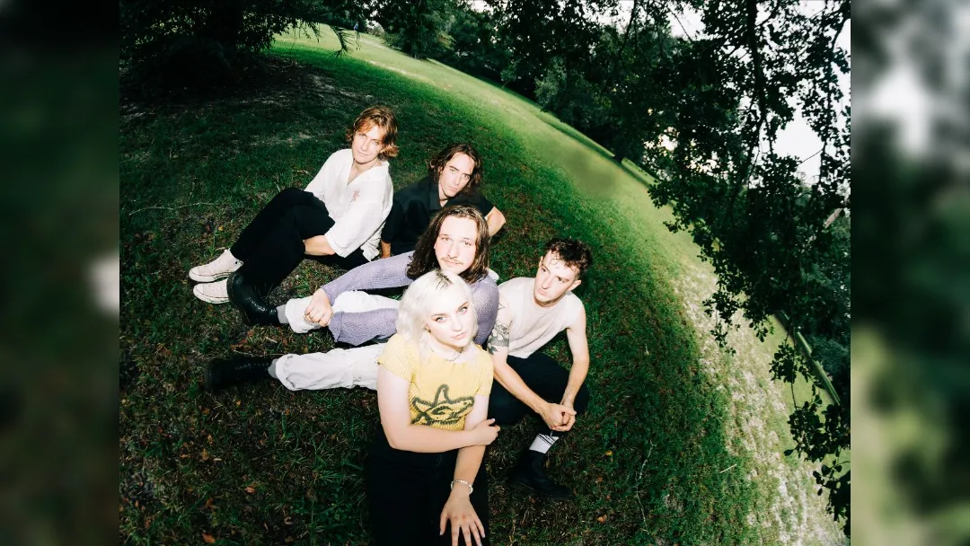 image of flipturn band sat on grass in a park
