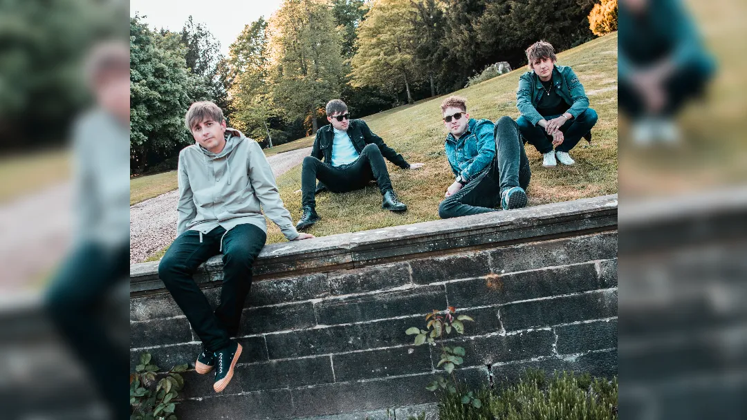 image of The Sherlocks sat on a wall and grass